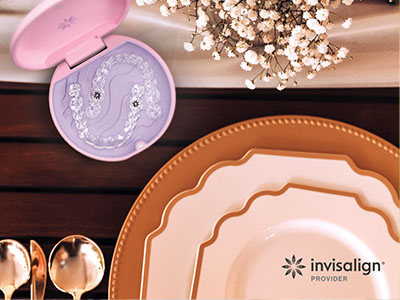 The image displays a collection of tableware, including plates, bowls, and a spoon rest, arranged on a wooden surface with a pink box containing dental floss in the background.